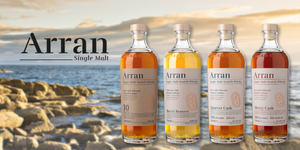 Arran Whiskey single malt bottles variey lined up with rock shores in backgrouns