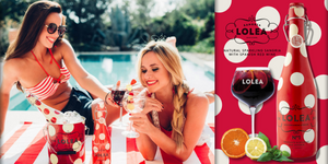 two young girls in bikini drinking a glass of Lolea Sangria by the swimming pool