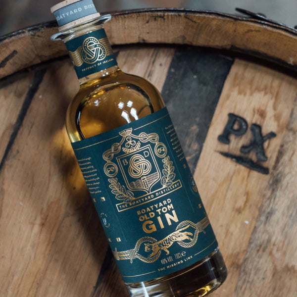 a bottle of Boatyard Old Tom Gin on a wooden barrel