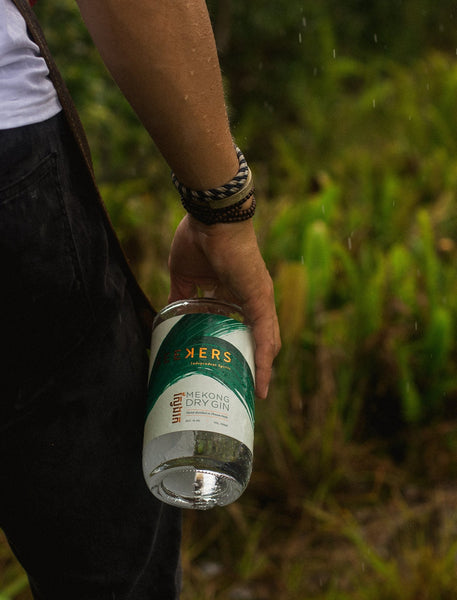 Seekers Mekong Dry Gin bottle hold by a hand with vegetation in the background